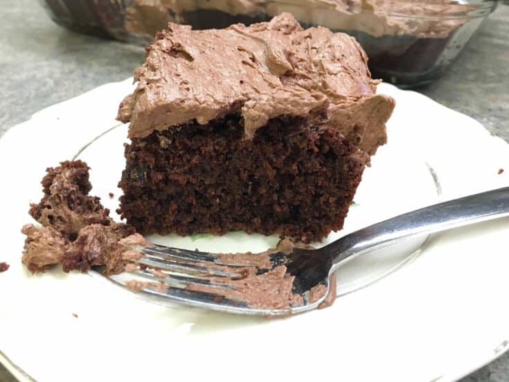 Chocolate cake with buttercream frosting on a plate with a fork