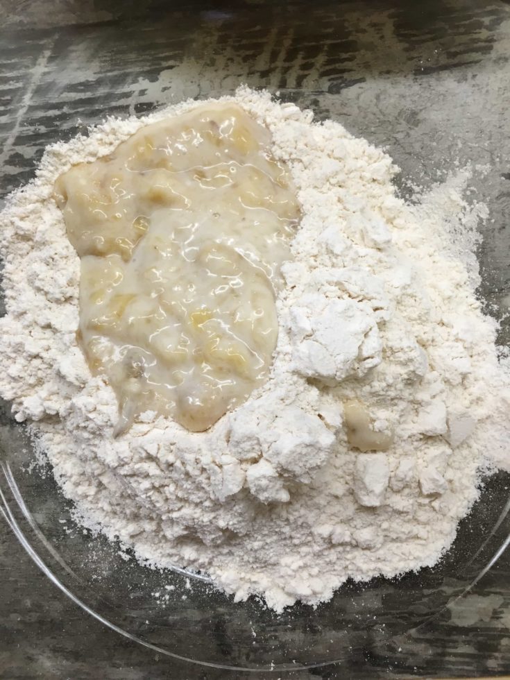 Flour and mashed bananas in a glass bowl