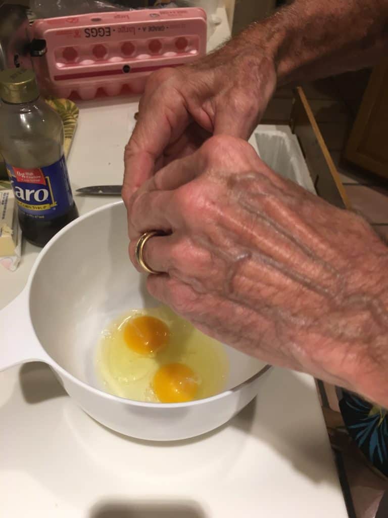 Breaking eggs into a bowl for pecan pie