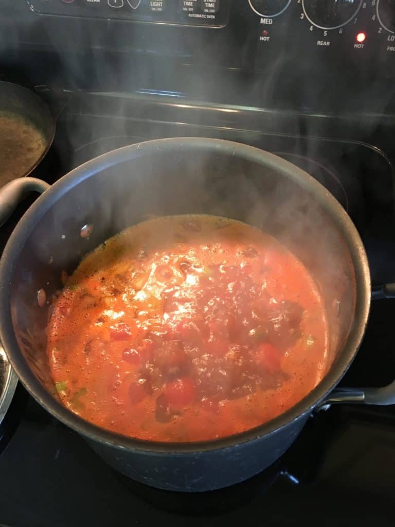 Beef and vegetable soup simmering on the stovetop. 