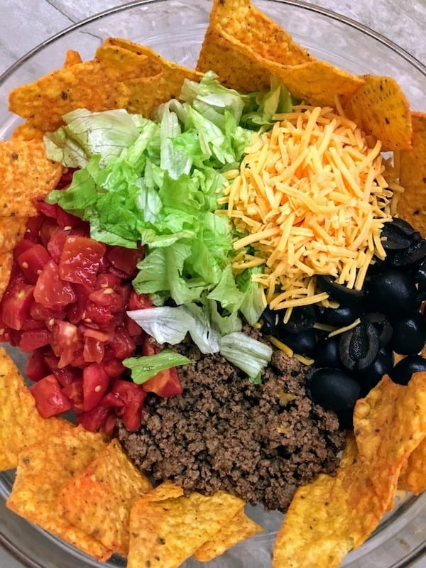 Easy Dorito Taco Salad Recipe is a cinch to make. It features spicy taco flavors that will please a crowd. Easy Dorito Taco Salad is perfect for a family supper, a tailgating party, football games, or any holiday. #dorito #taco #salad #supper #dinner