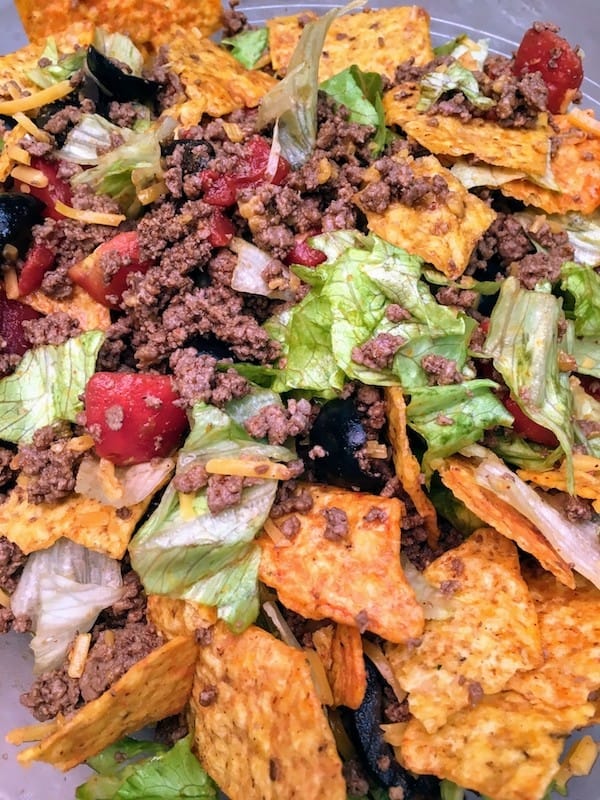 Easy Dorito Taco Salad Recipe is a cinch to make. It features spicy taco flavors that will please a crowd. Easy Dorito Taco Salad is perfect for a family supper, a tailgating party, football games, or any holiday. #dorito #taco #salad #supper #dinner