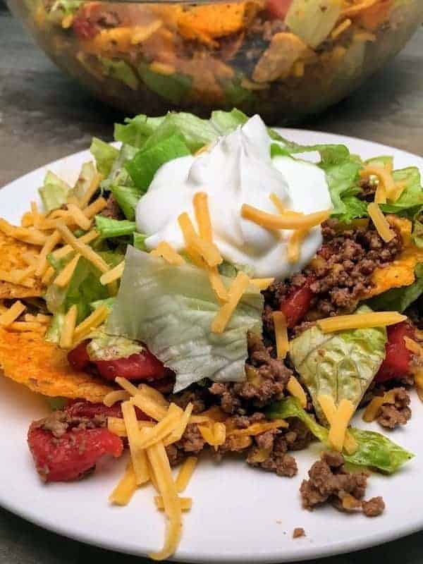 Easy Dorito Taco Salad Recipe is a cinch to make. It features spicy taco flavors that will please a crowd. Easy Dorito Taco Salad is perfect for a family supper, a tailgating party, football games, or any holiday. #dorito #taco #salad #supper #dinner