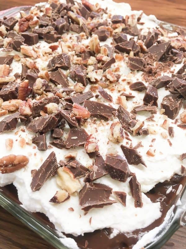 Chocolate layer dessert with a graham cracker crust, homemade whipped cream, chocolate pudding, and cream cheese is a delicious recipe. The easy recipe is the perfect dish for a party, the holidays, or for dessert at home.