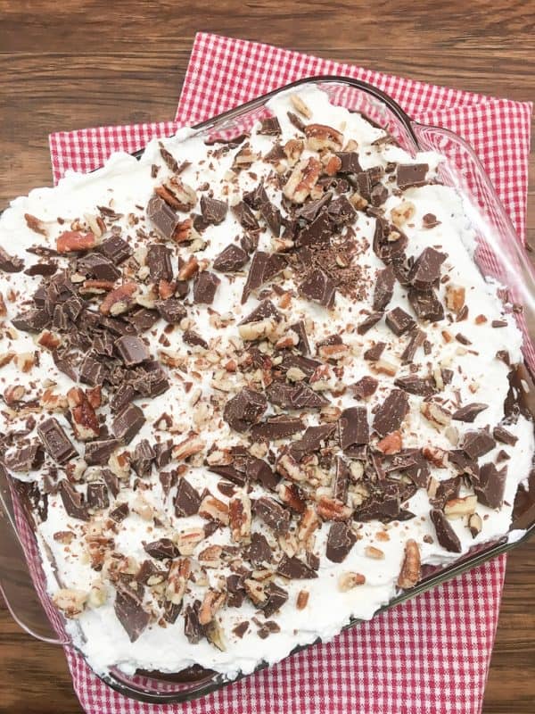 Chocolate layer dessert with a graham cracker crust, homemade whipped cream, chocolate pudding, and cream cheese is a delicious recipe. The easy recipe is the perfect dish for a party, the holidays, or for dessert at home.