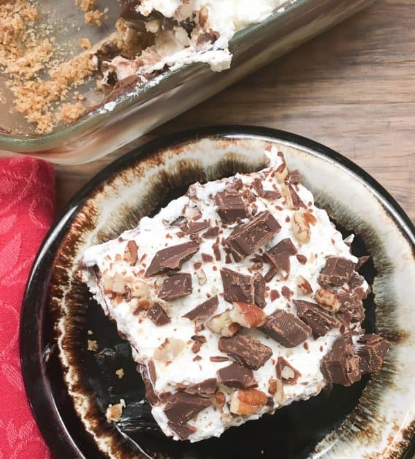 Chocolate layer dessert with a graham cracker crust, homemade whipped cream, chocolate pudding, and cream cheese is a delicious recipe. The easy recipe is the perfect dish for a party, the holidays, or for dessert at home.