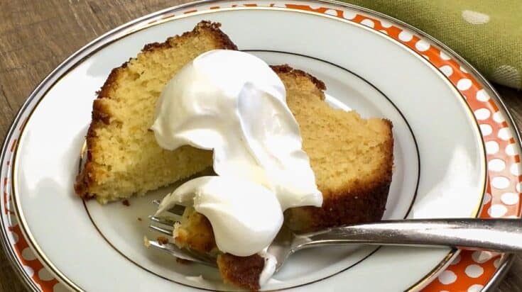 Pound cake with whipped cream on a plate with a fork