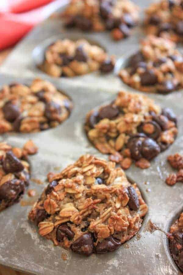 Mini oatmeal muffins with banana and chocolate chips in a metal muffin pan.