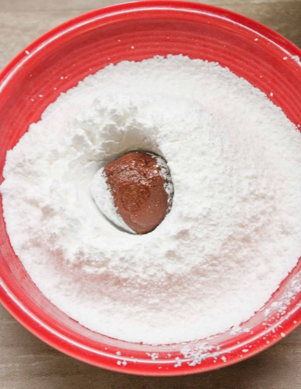 Powdered sugar with a chocolate and chewy crinkle cookie.