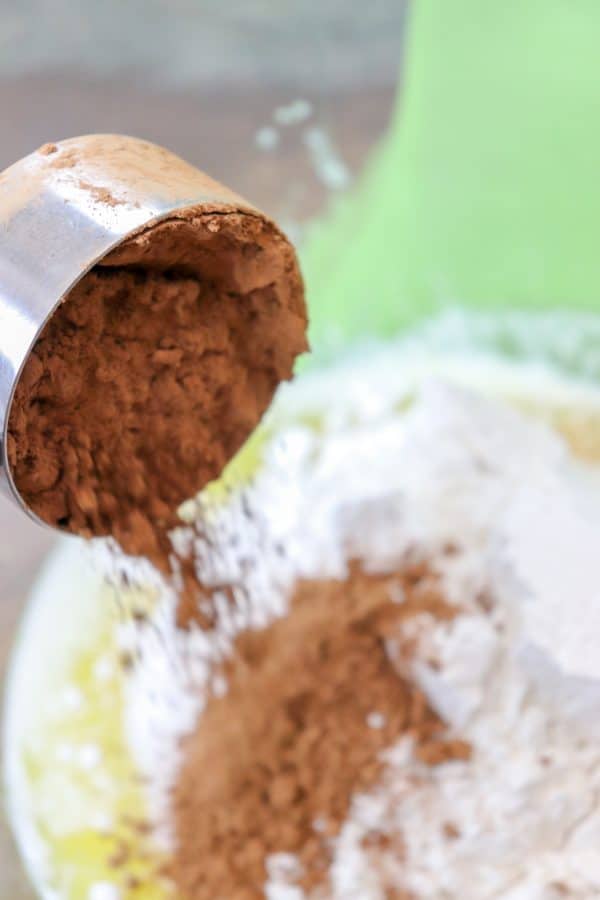 Picture of cocoa being poured into a brownie mixture. 