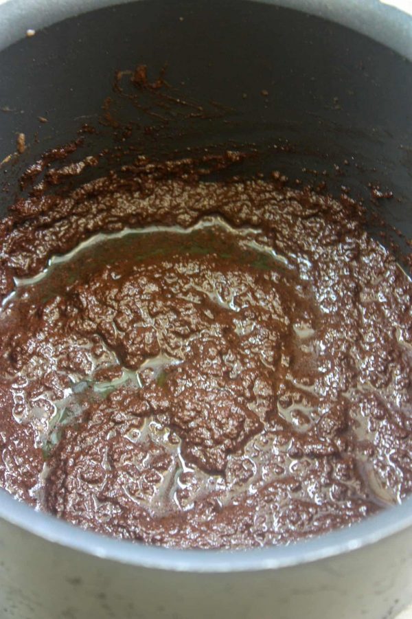 Picture of butter, half and half, and unsweetened cocoa melting in a saucepan. 