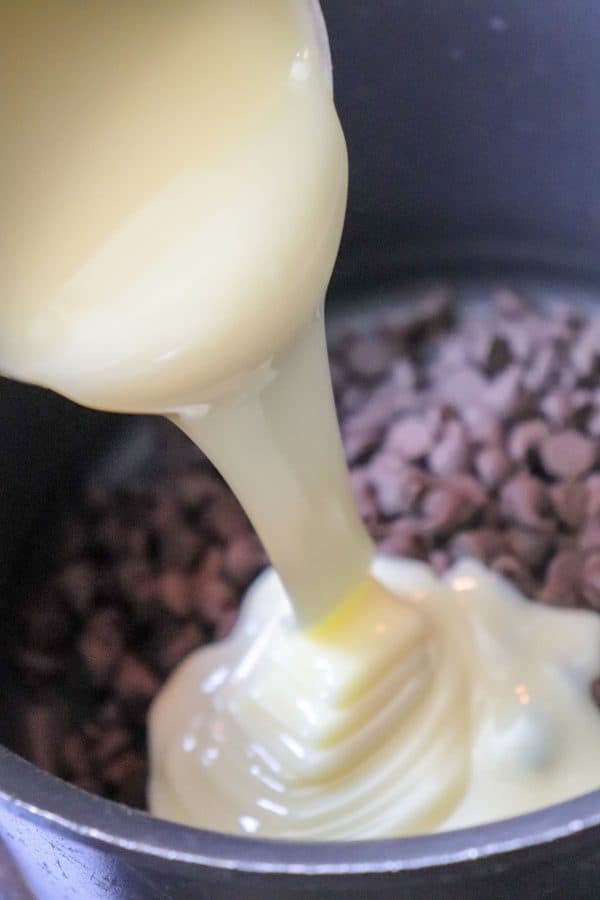 Picture of sweetened condensed milk pouring into a saucepan.