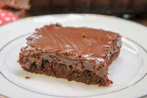 Picture of a brownie with fudge frosting on top.