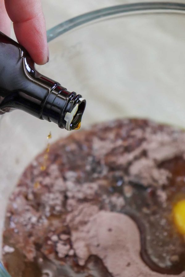 Picture of pouring vanilla into a glass bowl. 