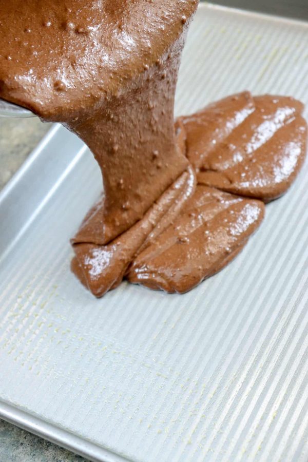 Picture of chocolate cake being poured into a jelly roll pan.