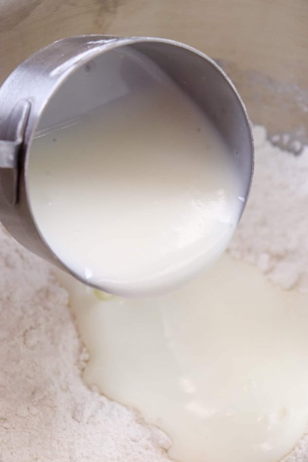 Picture of buttermilk being poured into a bowl of flour