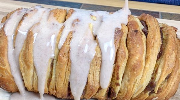 Picture of icing being poured over the pumpkin pull apart bread.