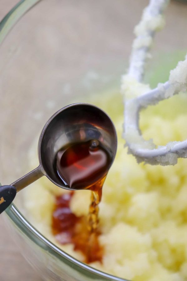 Picture of vanilla being poured into a glass bowl. 