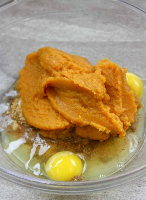 Picture of pumpkin in a bowl with seasonings, eggs, and sugar.