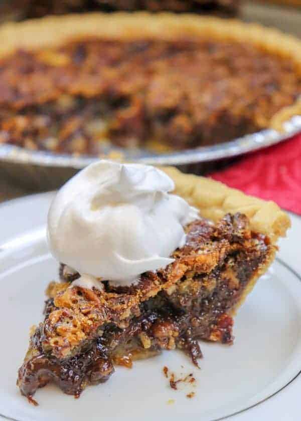 Picture of pecan pie with whipped cream on top.