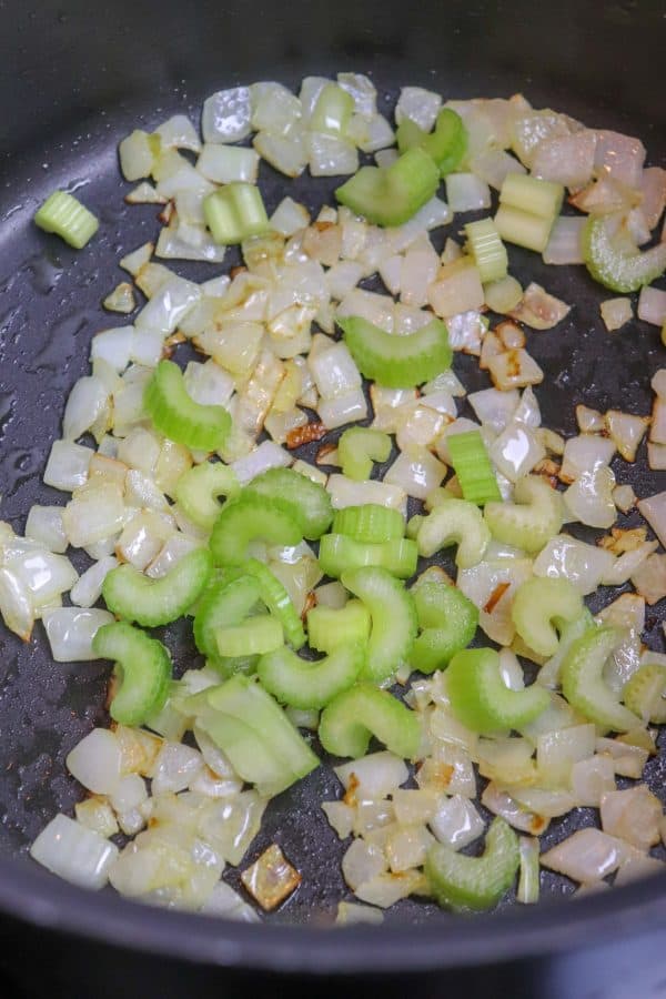 Picture of celery, onions, and oil in a saucepan. 