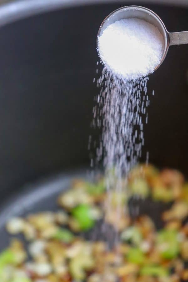 Picture of salt being poured into a saucepan. 