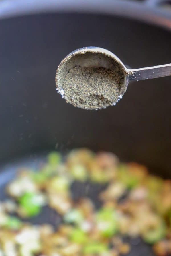 Picture of pepper being poured into the soup