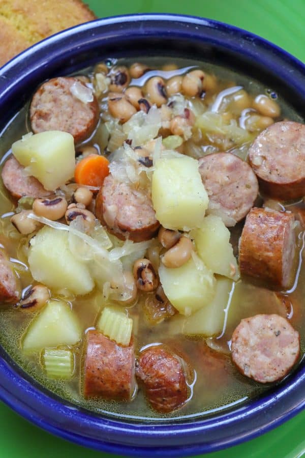 Picture of black eyed pea soup with sausage in a blue bowl