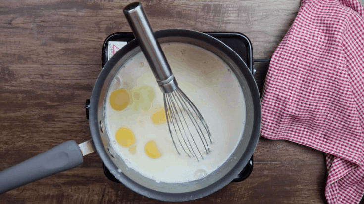 Picture of yolks and milk in a saucepan.