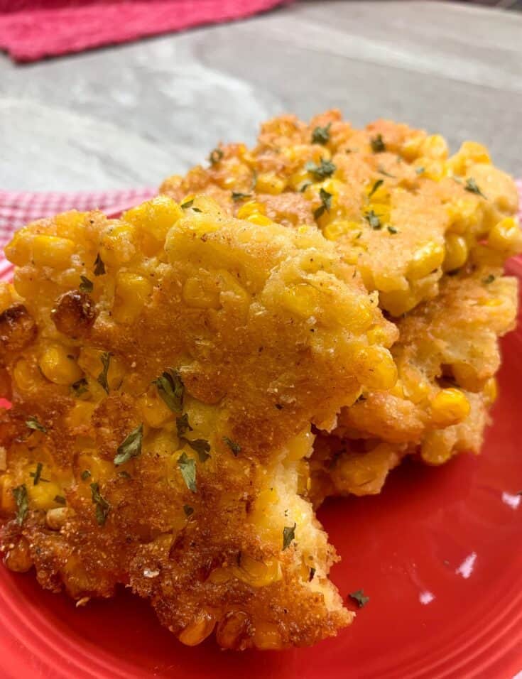 Picture of corn fritters on a red plate.