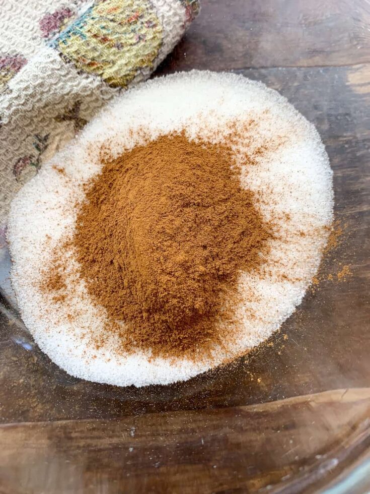 White sugar in a glass bowl with cinnamon on top