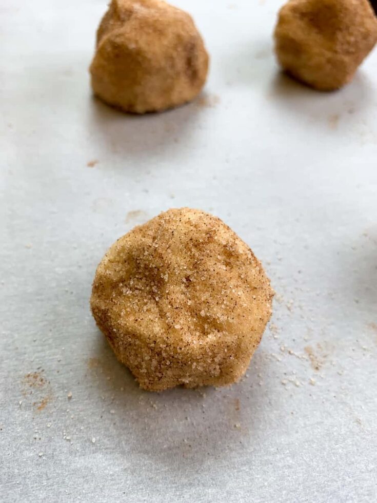 Snickerdoodle dough on a cookie sheet with parchment paper