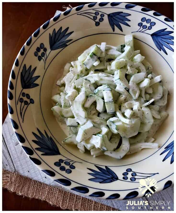 Cucumbers with a creamy dressing in a blue and white bowl