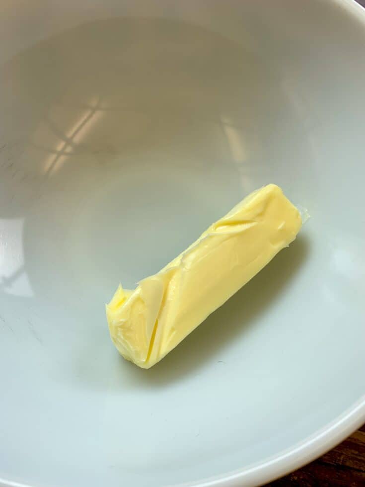 A stick of butter in a white bowl
