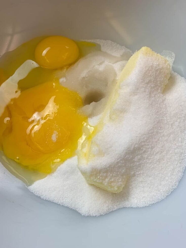 Eggs, butter, and sugar in a white bowl