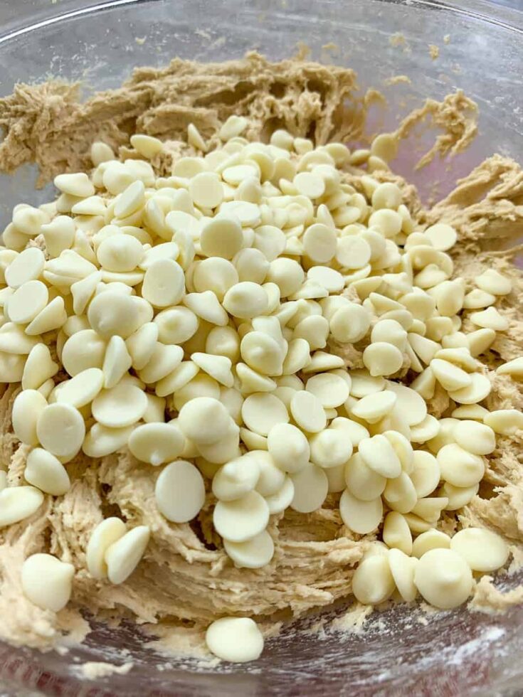 White chocolate chips in a glass bowl with cookie dough