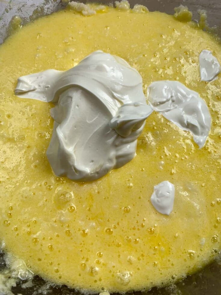 Sour cream, sugar, eggs, and butter in a glass bowl