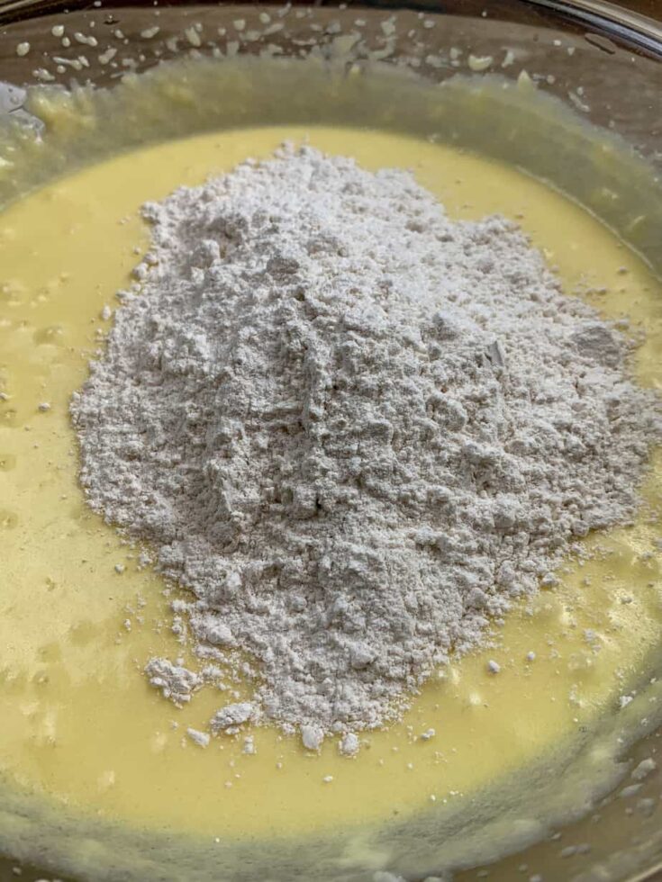 Flour in a glass bowl with lemon cake batter