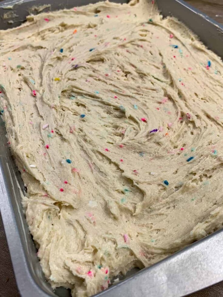 Cookie bar dough spread out into a cake pan