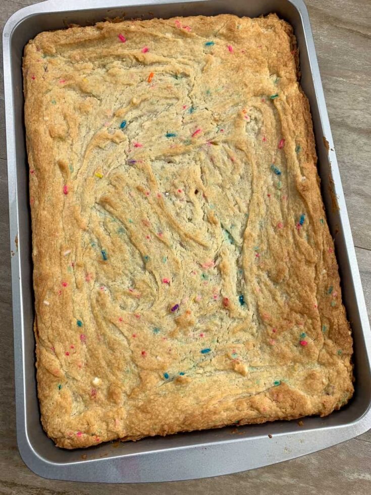 A baked cookie bar in a cake pan.