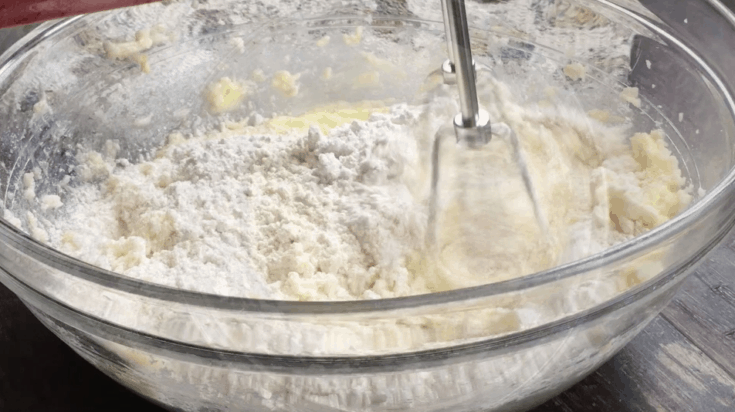 Snickerdoodle dough being mixed with a hand mixer