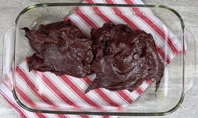 Brownie batter inside of a glass casserole dish.