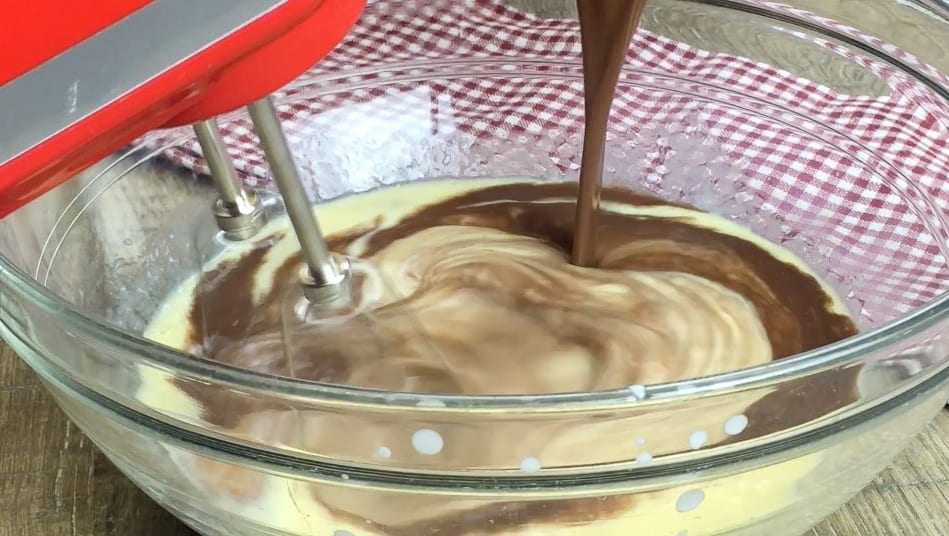 Chocolate being poured into a bowl of ingredients.