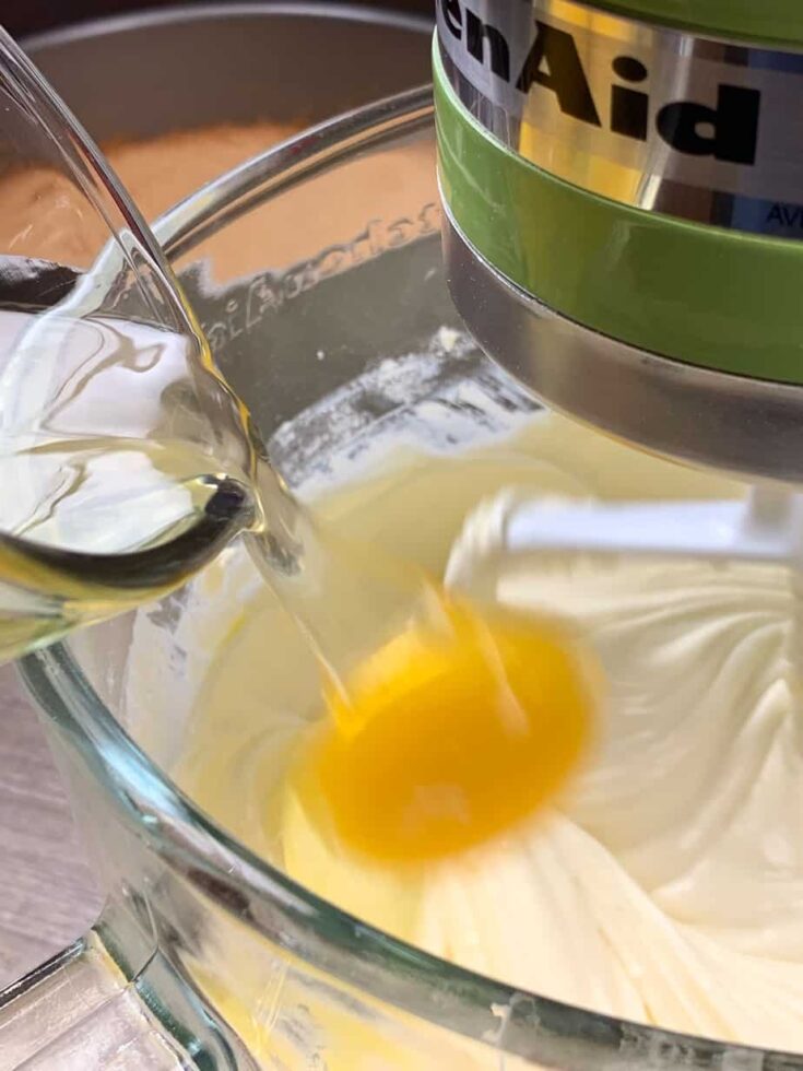 Eggs being poured into a bowl with cheesecake ingredients