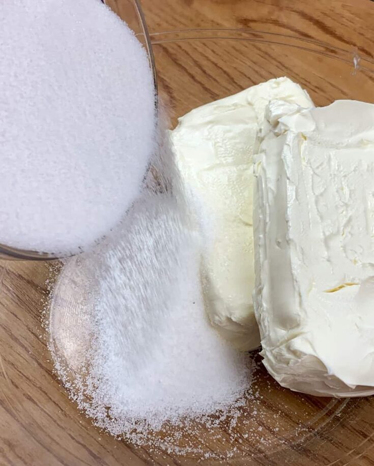 Cream cheese and sugar in a glass bowl