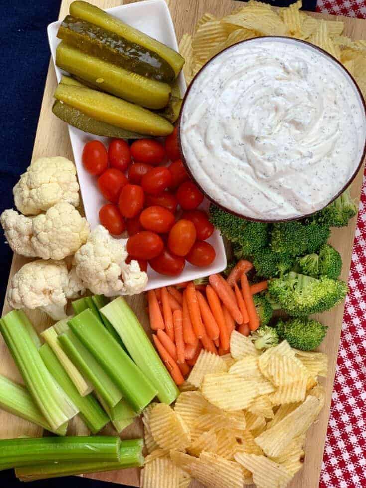 Sour cream dip and veggies on a cutting board