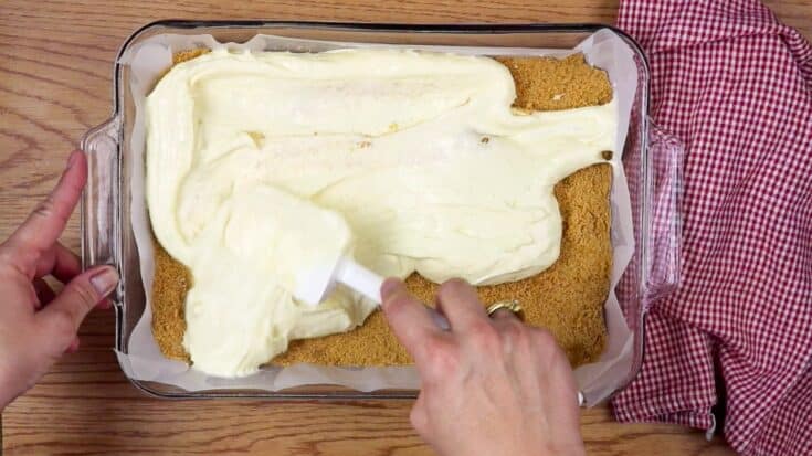 Spreading the cheesecake mixture over the breadcrumbs