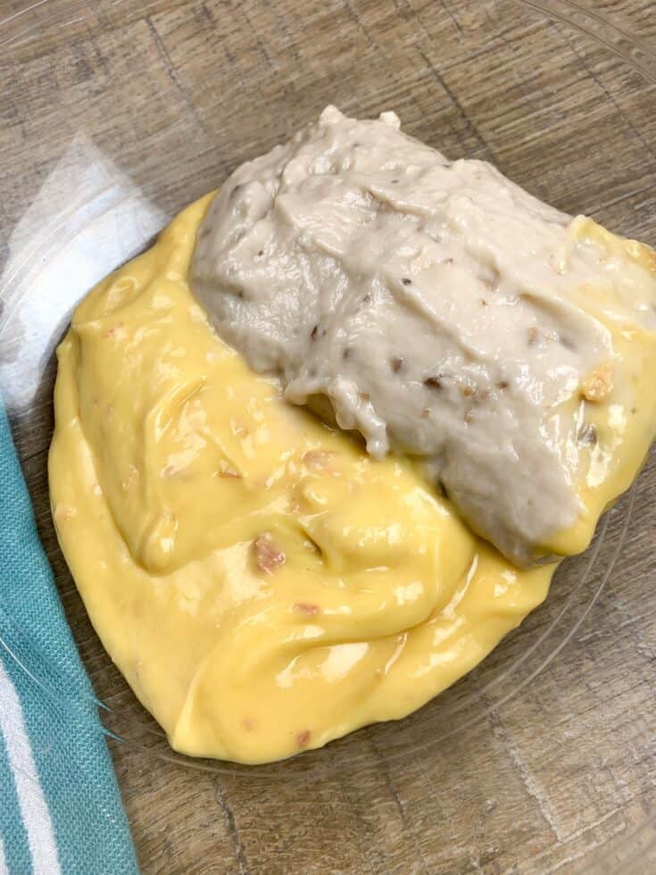 Can of cream of chicken soup and mushroom soup in a glass bowl