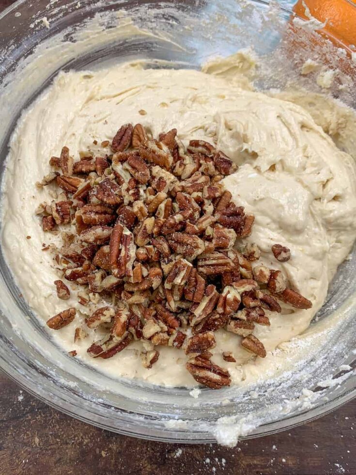 Pecans in a bowl with banana bread mixture