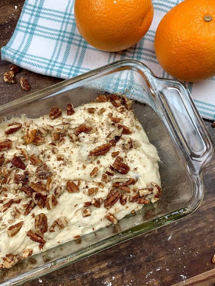 Banana bread mixture with pecans in a bread dish.